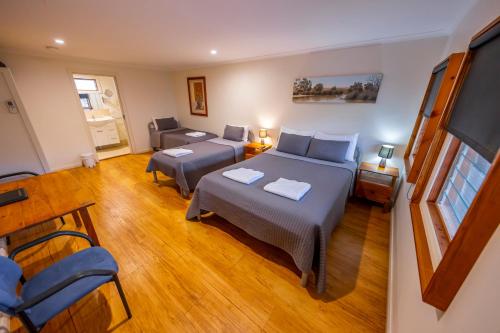 1 dormitorio con 2 camas y sala de estar en The Silverton Hotel en Silverton