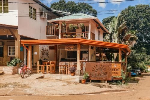サンタ・カタリナにあるSunset Catalinaのテーブルと椅子のあるレストランを併設する建物