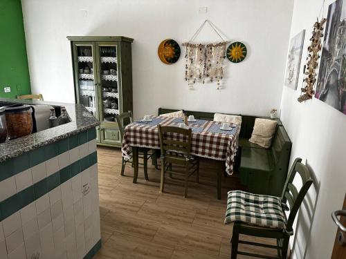 uma sala de jantar com uma mesa e cadeiras numa cozinha em Beppo's B&B em Carbonia