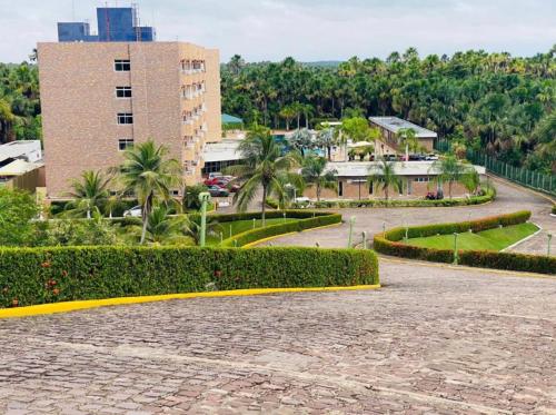 a park with bushes and a building and trees at Apartamento no Grand Lençóis em Barreirinhas in Barreirinhas