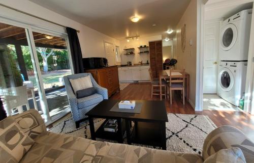 a living room with a couch and a table and a kitchen at Valleyview in Courtenay