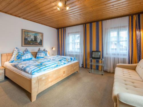 フラッハウにあるSiglavy Flachauのベッドルーム(ベッド1台、ソファ、テレビ付)