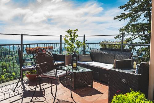 un patio con divano e sedie sul balcone. di Casa Grinta B&B a Città della Pieve