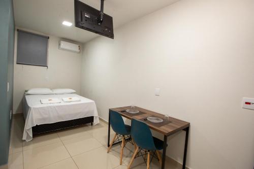 a room with a bed and a table and chairs at Jahu Center Plaza Flats in Jaú