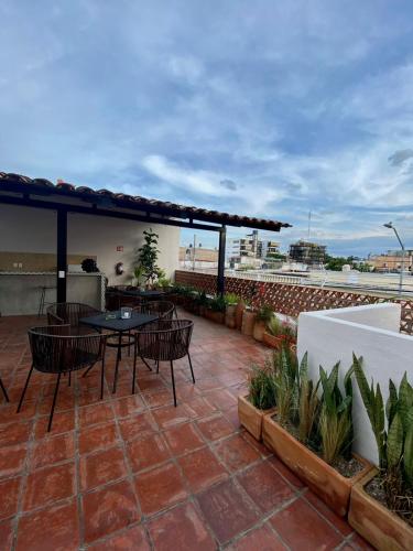 a patio with tables and chairs on a roof at Casa Irake in Guadalajara