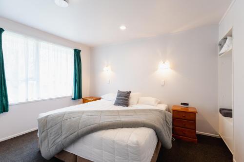 a bedroom with a large bed and a window at Highway Lodge Motel in Balclutha