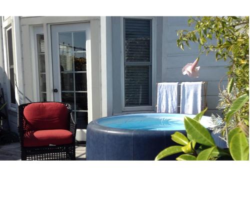 un bain à remous sur une terrasse couverte avec une chaise rouge dans l'établissement Beautiful Edwardian Victorian Homestay B&B, à San Francisco