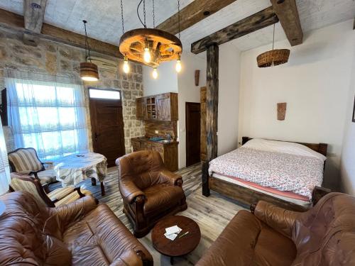 een woonkamer met een bed en lederen meubels bij Bed & Wine Djonovic in Virpazar
