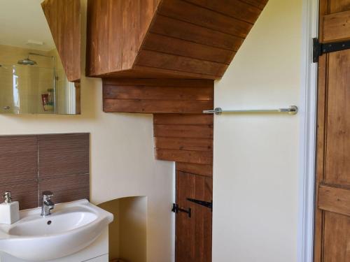 een badkamer met een wastafel en een spiegel bij Arun Cottage in Loxwood