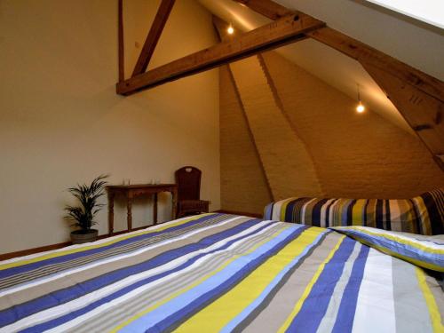 a bed in a room with an attic at Holiday Home with pond in Poperinge in Beveren