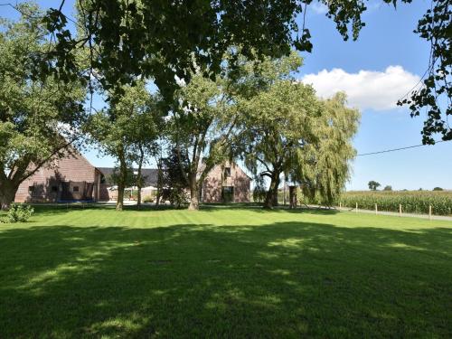 a large yard with trees and a house at Holiday Home with pond in Poperinge in Beveren