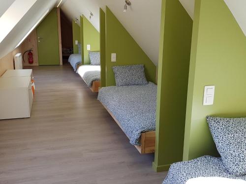 a row of beds in a room with green walls at Holiday Home with pond in Poperinge in Beveren