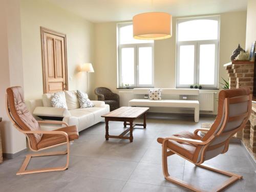 a living room with a couch and a table and chairs at Holiday Home with pond in Poperinge in Beveren
