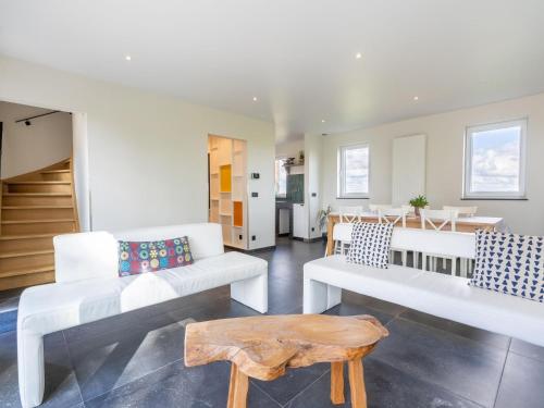 a living room with white furniture and a table at Holiday Home with pond in Poperinge in Beveren