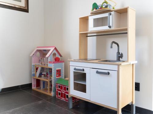 a toy kitchen with a sink and a microwave at Holiday Home with pond in Poperinge in Beveren