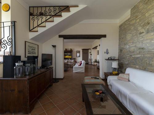 a living room with a couch and a tv at Private villa with swimming pool in the heart of Umbria in Bevagna