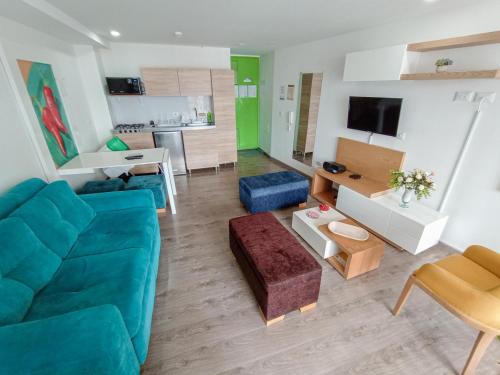 uma sala de estar com um sofá azul e uma cozinha em Apartamento Loft Edificio Soho 905 em Armênia