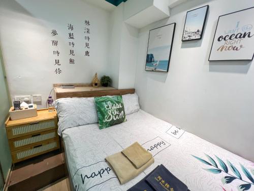 Habitación pequeña con cama y escritorio. en AMU Dreamhouse 阿木旅舍, en Hong Kong