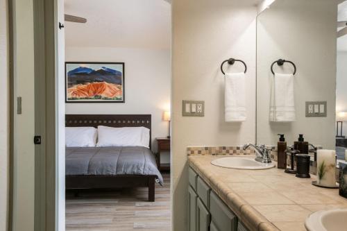 a bathroom with a bed and a sink and a mirror at Casa Chiliwood in Albuquerque