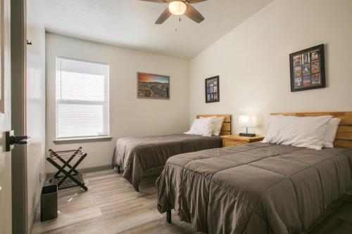 a bedroom with two beds and a ceiling fan at Casa Chiliwood in Albuquerque