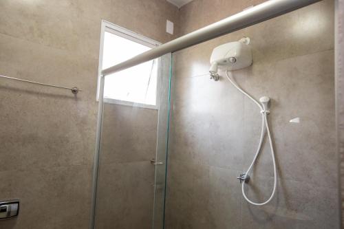 a bathroom with a shower with a glass door at Jahu Center Plaza Flats in Jaú
