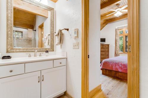 a bathroom with a sink and a mirror and a bed at The Potato House in Banner Elk