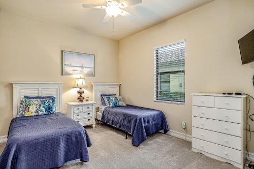a bedroom with two beds and a ceiling fan at Lisburn Lake View in Bonita Springs