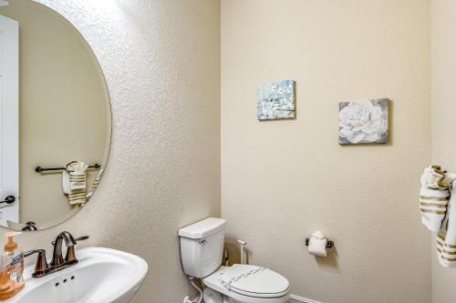 a bathroom with a toilet and a sink and a mirror at Lisburn Lake View in Bonita Springs