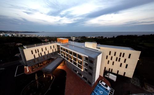 an overhead view of two buildings with the ocean in the background at Grand Mer Hotel Seogwipo Ocean in Seogwipo