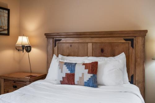 a bedroom with a white bed with a wooden headboard at Mule Deer Cabin in West Yellowstone