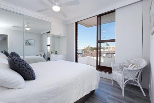 a bedroom with a large bed and a balcony at Bellevue, 7 4 Donald Street - renovated unit with air con and Wi-Fi with views & central to CBD in Nelson Bay