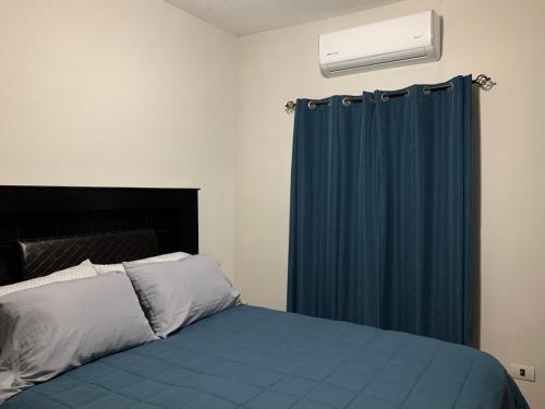 ein Schlafzimmer mit einem Bett und einem blauen Vorhang in der Unterkunft Ariana’s house in Puerto Peñasco