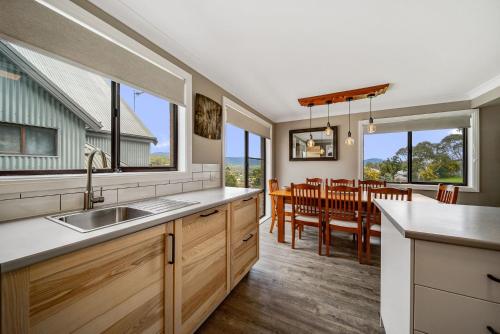 a kitchen with a sink and a dining room at Petersdorf 2 Jindabyne Townhouse in Jindabyne