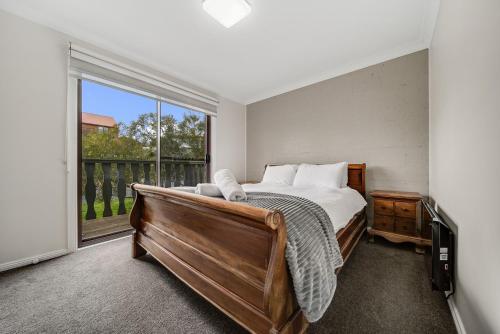 a bedroom with a bed and a large window at Petersdorf 2 Jindabyne Townhouse in Jindabyne
