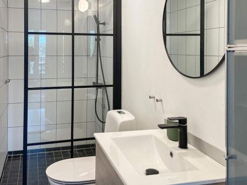 a bathroom with a sink and a toilet and a mirror at Stylish Holiday Apartment on Oland in Borgholm