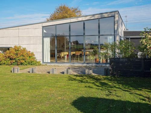 a house with large glass windows on the side of it at 6 person holiday home in Væggerløse-By Traum in Væggerløse
