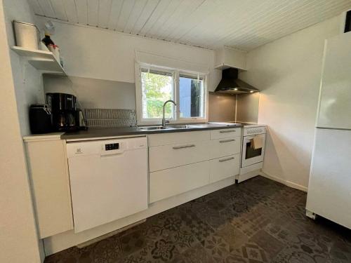 a kitchen with white cabinets and a sink and a window at Holiday home HJÄRNARP II in Hjärnarp