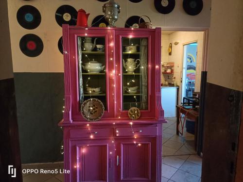 a pink cabinet with dishes in it in a room at Hostel Apollo in Ząbkowice Śląskie