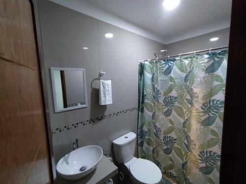 a bathroom with a toilet and a shower curtain at Urpi Hotel in Paracas