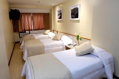 Ліжко або ліжка в номері Mengo Palace Hotel