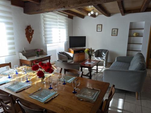 a living room with a wooden table and a couch at Gîte familial à Barret : Jardin clos, équipement bébé, proche circuits de rando et Jonzac - FR-1-653-155 in Barret