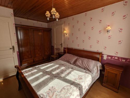 a bedroom with a bed and a wall with flowers at Gîte familial à Barret : Jardin clos, équipement bébé, proche circuits de rando et Jonzac - FR-1-653-155 in Barret