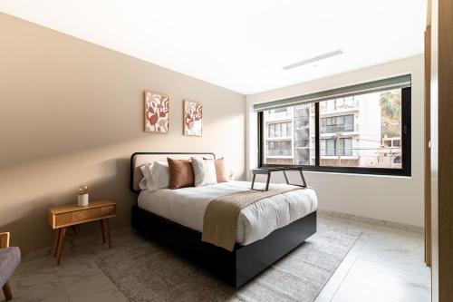 a bedroom with a bed and a large window at Lumina at Cardinal Cabo San Lucas in Cabo San Lucas