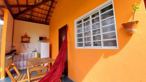 um quarto com uma mesa, uma cozinha e uma janela em Chalés Flor de Manacá em Alto Paraíso de Goiás