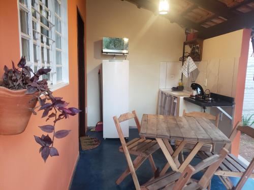 a small kitchen with a table and chairs in a room at Chalés Flor de Manacá in Alto Paraíso de Goiás