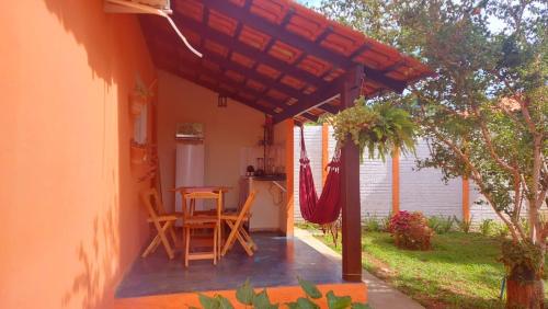 a patio with a table and chairs under a pergola at Chalés Flor de Manacá in Alto Paraíso de Goiás