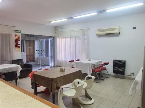 ein Wohnzimmer mit Tischen und Stühlen sowie eine Küche in der Unterkunft Hotel Anmara in San Juan