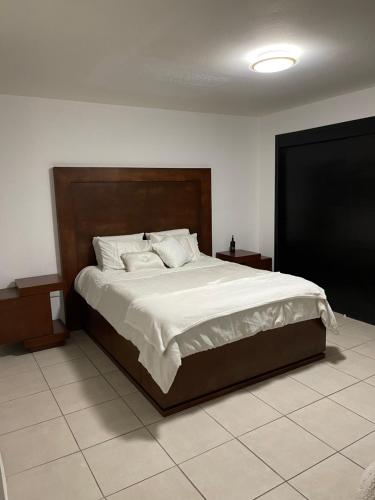 a bedroom with a large bed with white sheets at Casa Luna 2 bedroom Condo 5 min to Border & Beach in Tijuana