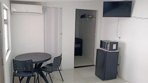 a kitchen with a table and chairs and a microwave at KITNET EM OLINDA CASA CAIADA A 50 MT DA PRAIA in Olinda
