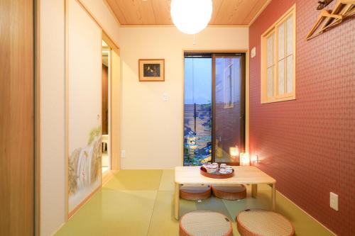 a room with a table and stools and a window at Shirakabanoyado - HOUKA 白樺の宿 - 芳華, Direct access to Umeda, Tsutenkaku, Tennoji in Osaka